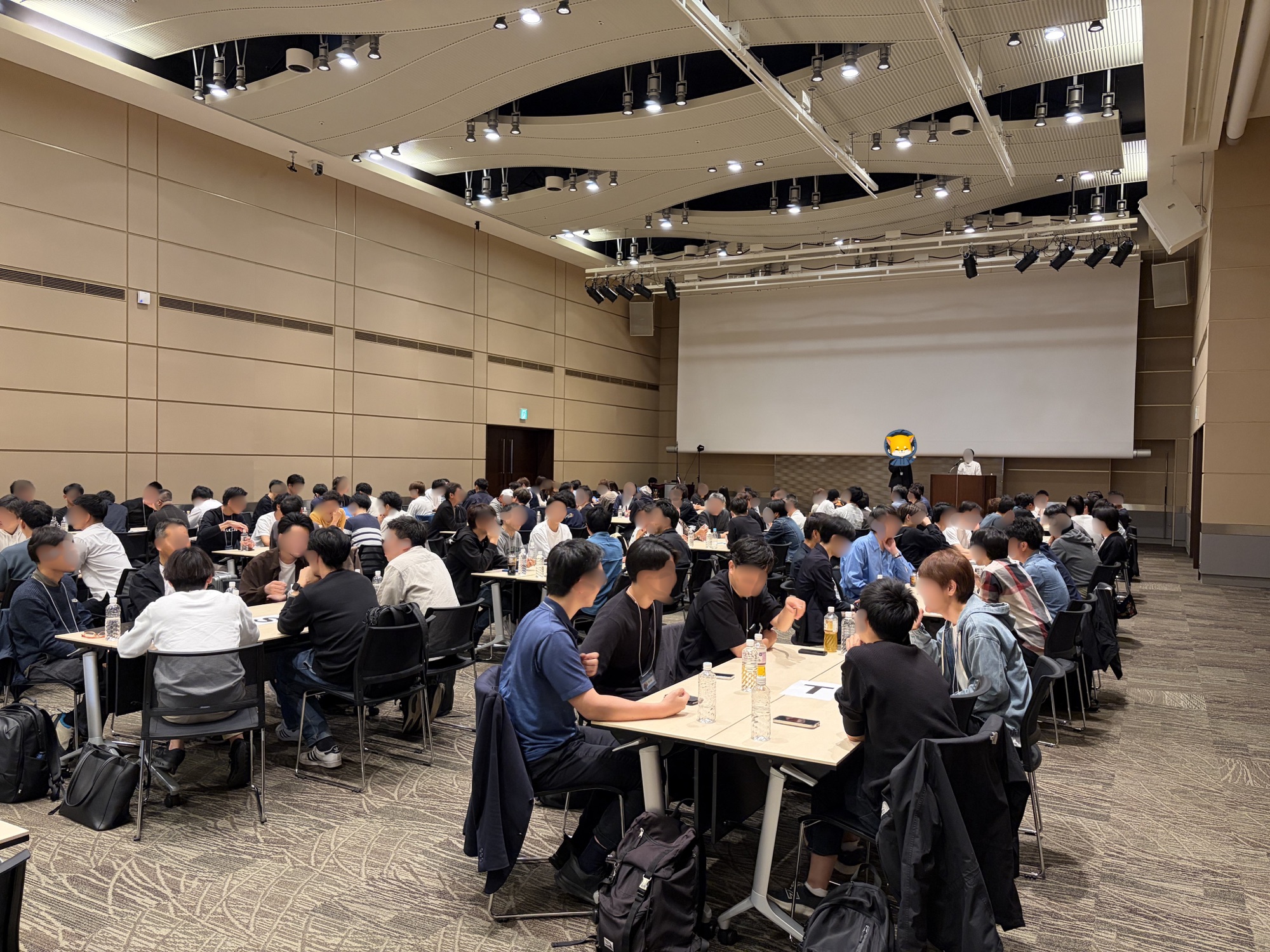合同交流会の会場。多くの参加者がテーブルを囲んで交流する様子